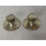 A pair of George V silver circular capstan ink wells with hinged lids 3¼" diameter,