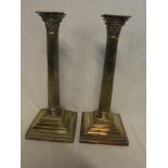 A pair of good quality silver plated Corinthian column candlesticks with fluted stems and square