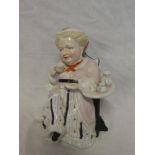 A Continental china tea caddy in the form of a seated female drinking tea 8" high