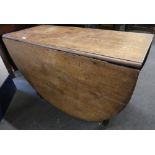 A George III oak oval drop-leaf dining table on square shaped supports