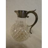 A late Victorian cut glass claret jug with silver mounted spout and scroll handle,