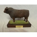 A good quality china figure of a Devon bull on mahogany base,