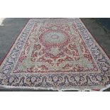 A good quality rectangular wool carpet with floral decoration on red and blue ground,