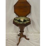 A Victorian walnut octagonal work table with fitted interior enclosed by a hinged lid on tripod