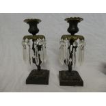 A pair of 19th Century bronze and gilt candlesticks with rustic tree stems and square shaped bases
