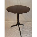 A 19th Century mahogany circular wine table with pie crust top on turned column with tripod base
