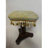 A Victorian mahogany piano-style stool with square upholstered seat on trefoil base