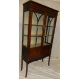 A late Victorian/Edwardian inlaid mahogany display cabinet with fabric lined shelves enclosed by
