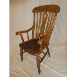 A beech and elm kitchen style carver armchair with lath back and shaped seat on turned tapered legs