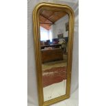 A rectangular dressing mirror in gilt arched frame,
