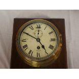 A ship's-style brass wall clock by Smith's Astral with painted circular dial in brass cylindrical