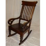 A late Victorian/Edwardian mahogany rocking chair with lath back and polished seat on turned