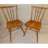 A set of six 1960's Ercol light elm dining chairs with spindle backs and shaped seats on turned