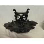 A Victorian cast iron boot scraper with scroll dished base