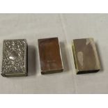 A silver rectangular matchbox holder with raised decoration and two other various plain silver