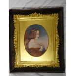 An ornate gilt rectangular picture frame decorated in relief with flowers with oval central insert,
