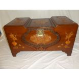 An Eastern carved camphor wood trunk with carved floral and character decoration and raised panels