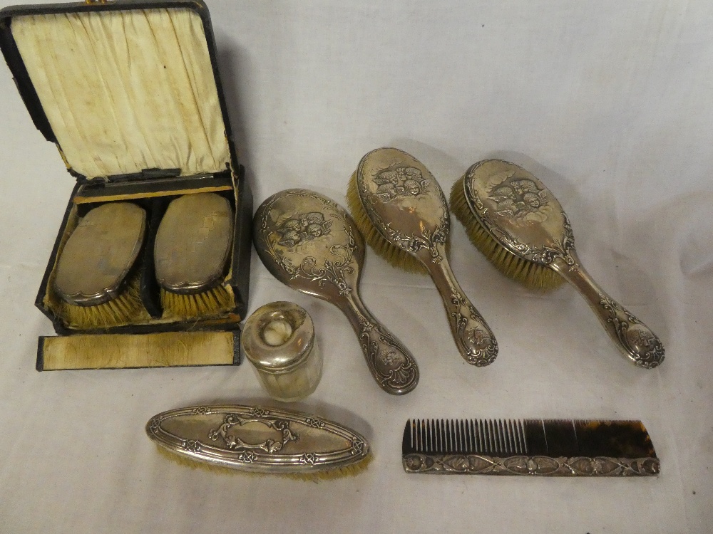 A silver mounted three-piece dressing set comprising a pair of hairbrushes and matching hand mirror