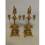 A pair of gilt spelter two branch ornamental candelabra with mask head and scroll decoration and