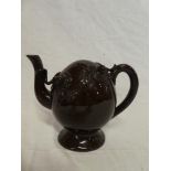 A 19th Century Cadogan pottery inverted oval tea pot with raised decoration on brown ground