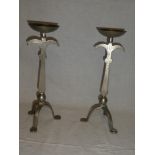 A pair of Arts & Crafts style beaten steel candlesticks on tripod bases