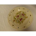 A Continental pottery circular charger with painted floral decoration,