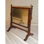 A small 19th Century rectangular mahogany framed toilet mirror on turned supports with scroll feet