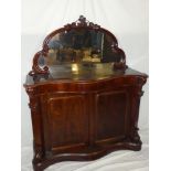 A Victorian figured mahogany serpentine fronted chiffonier with cupboard enclosed by two panelled