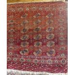 A small 19th Century Eastern Bokhara hand-knotted wool rug with geometric decoration on red ground,