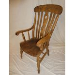 A beech and elm kitchen style carver armchair with lath back and shaped seat on turned tapered legs