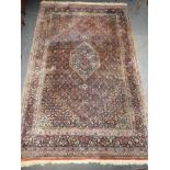 A Persian hand knotted Tabriz wool rug with geometric decoration on red & blue ground,