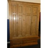An old polished pine house keepers cupboard with shelves enclosed by four narrow panelled doors