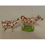 A 19th Century Sunderland pottery cow creamer with lustre painted decoration on green oval base and