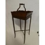 An Edwardian walnut rectangular sewing stand with scroll handle on square shaped legs,