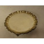 A late Victorian silver circular waiter tray with pie-crust edge on three scroll feet, 6" diameter,