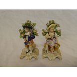 A pair of 19th Century porcelain figures of a young boy and girl with sheep and birds,