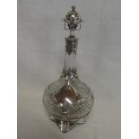 A good quality cut glass globular shaped decanter decorated with silver plated scroll mounts on