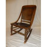 A 19th Century beech rocking chair with embossed seat and back pad on turned supports