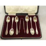 A set of six George V silver coffee spoons with decorated handles together with matching sugar