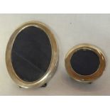A silver oval photo frame and one other similar circular silver photo frame (2)