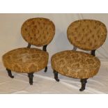 A pair of Victorian ebonised salon chairs upholstered in buttoned floral fabric on turned legs with