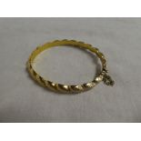 A 9ct gold oval bangle with rope twist decoration
