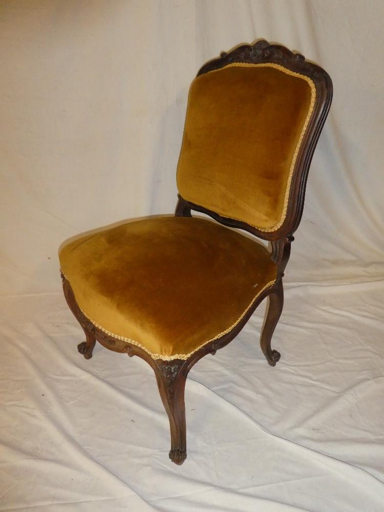 A 19th Century rosewood occasional chair with seat and back pad upholstered in fabric on scroll