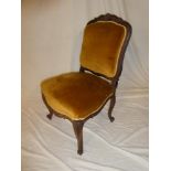 A 19th Century rosewood occasional chair with seat and back pad upholstered in fabric on scroll