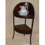 A 19th Century mahogany curved two tier wash stand with bowl recess supporting a blue and white