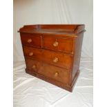 A Victorian figured walnut chest of two short and two long drawers below gallery rail on plinth