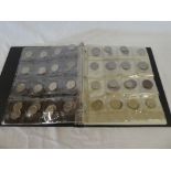 A folder album containing a collection various coins including numerous brass and pressed metal