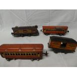 A Lionel O gauge tin plate locomotive together with two tin plate carriages and a US mail wagon