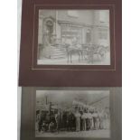 Two early black and white photographs including a group scene of labourers by a steam engine