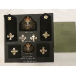 A small display of Royal Naval Chaplins badges including cap and beret badges, cuff insignia,